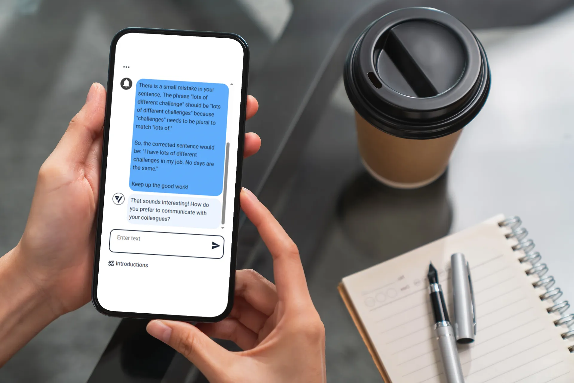 A student using their smartphone to view automated feedback on their written English, which has been provided by the Versa practice application.